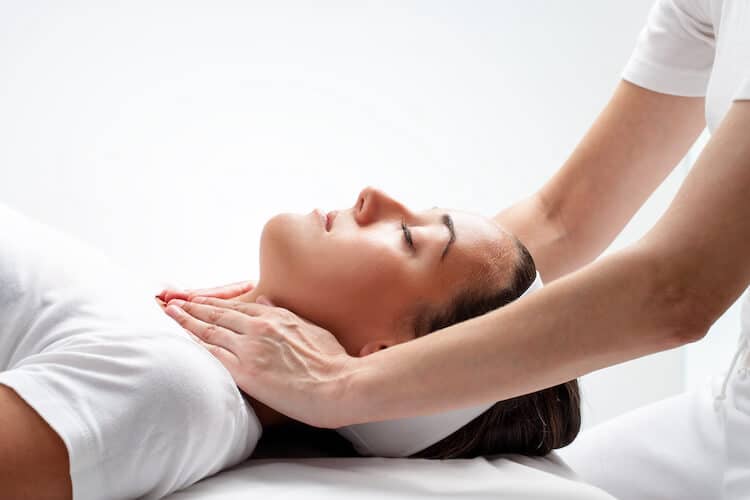 A woman laying on her back receiving a Yukido therapy